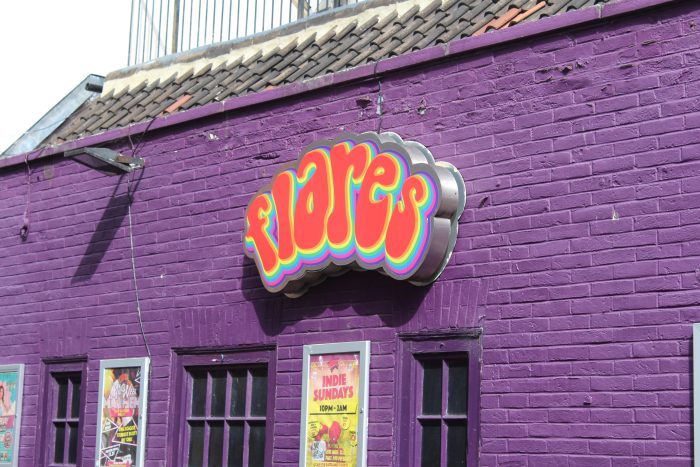 Exterior of Flares nightclub. Flares sign in the centre on purple brick building.