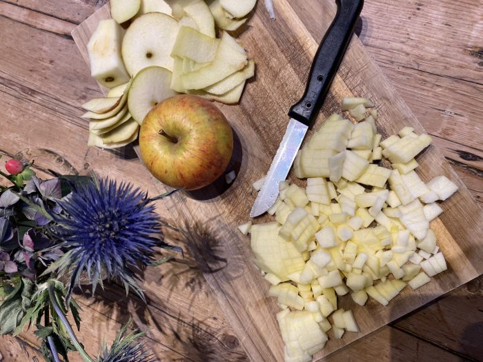 Chopped apples a thistle and a chopping board