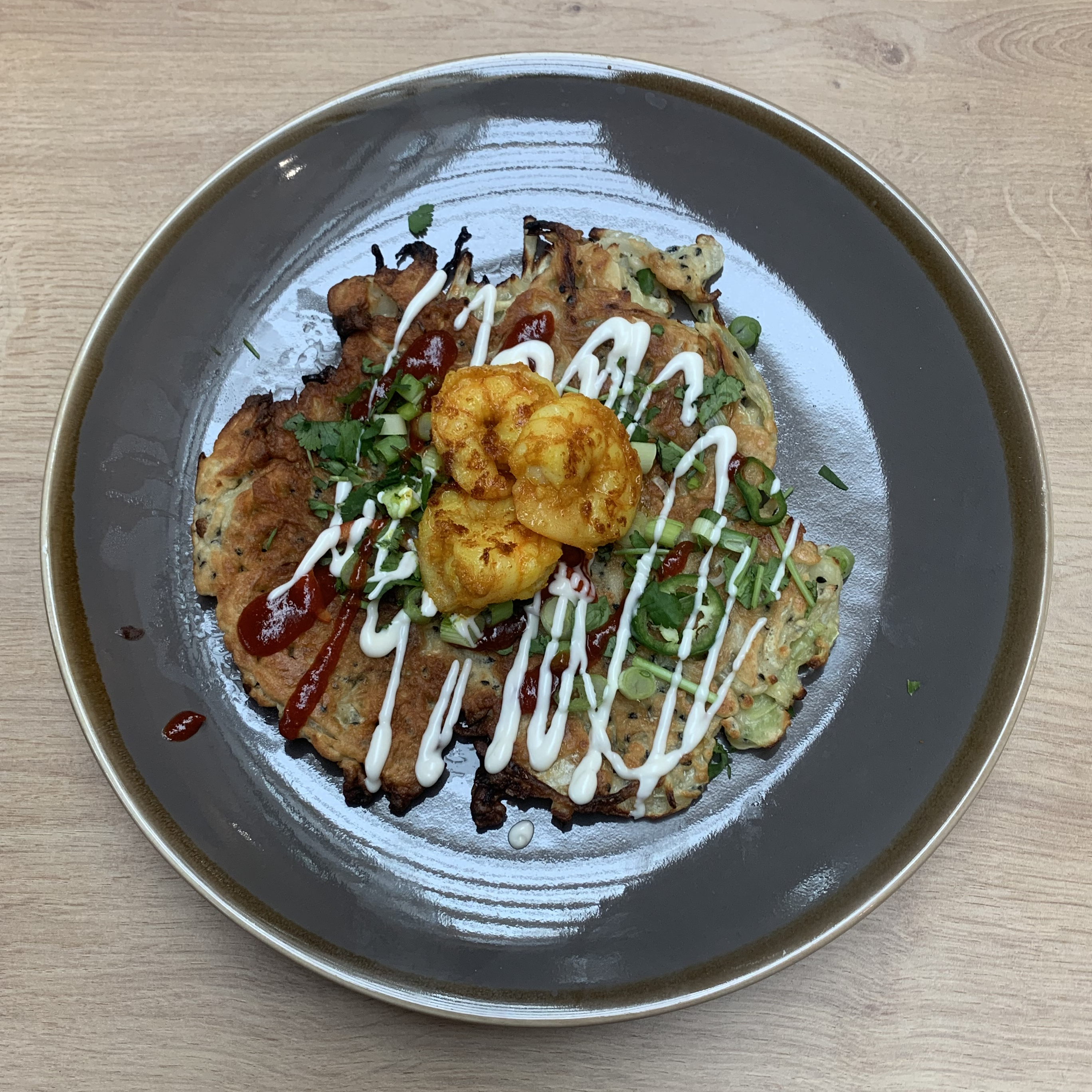 Okonomiyaki - japanese pancake topped with prawns and sriracha sauce