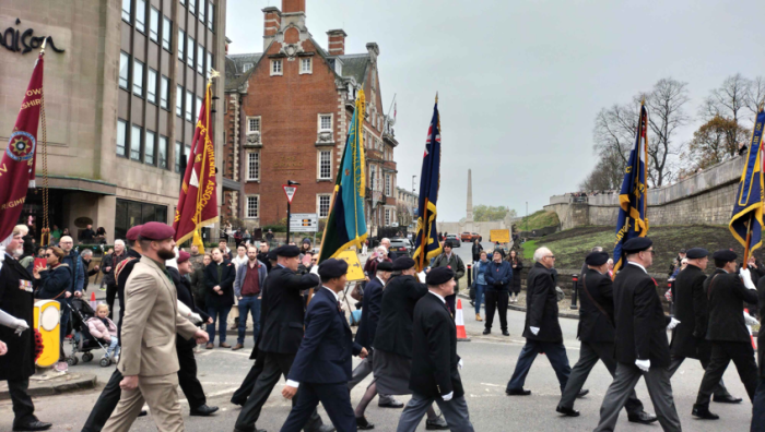 Procession marches along the street carrying flags