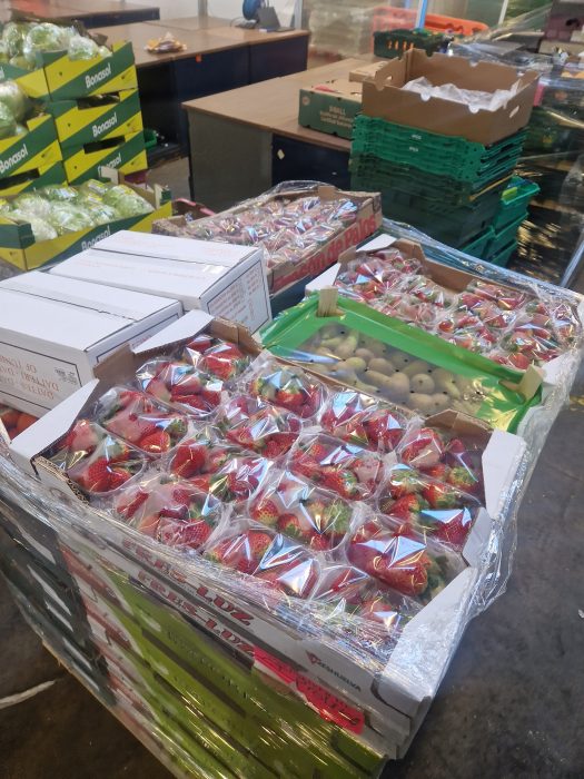 A stack of boxes of strawberries in a warehouse.
