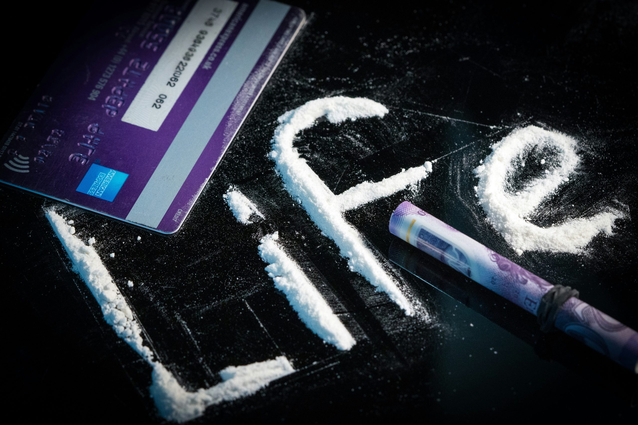 The word "life" written in a drug-like powder, next to cash and a debit card